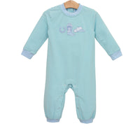 A baby long-sleeve footless one-piece sleeper with light blue and white horizontal stripes, featuring a small embroidered whale design on the chest and light blue ribbed cuffs and hem, shown on a wooden hanger against a white background.