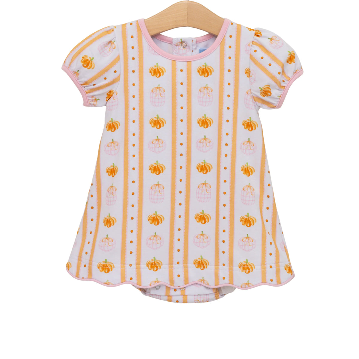 A toddler girl's short-sleeve top on a wooden hanger, featuring a white base with vertical orange stripes, small orange pumpkins, and tiny orange dots, finished with a pink collar and trim.