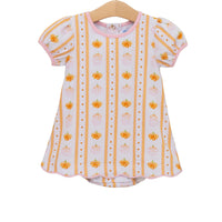 A toddler girl's short-sleeve top on a wooden hanger, featuring a white base with vertical orange stripes, small orange pumpkins, and tiny orange dots, finished with a pink collar and trim.
