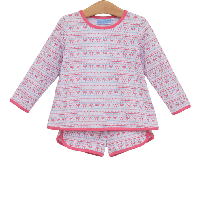 A two-piece children's set consisting of a long-sleeve top and matching shorts, hanging on a wooden hanger against a plain white background. The pajamas feature a white base with pink horizontal stripes containing small red bow motifs, and solid pink trim on the collar, cuffs, and hem.
