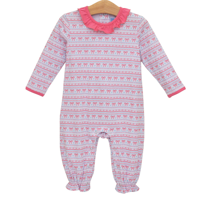A baby long-sleeve footless one-piece jumpsuit with an allover pink and white Nordic-style pattern, featuring a ruffled pink collar and pink cuffs, hanging on a wooden hanger against a white background.